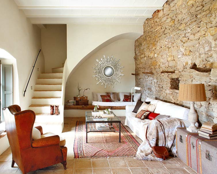 stenen muur woonkamer rustiek tapijt vintage leunstoel binnentrap
