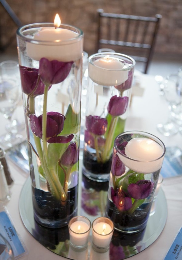 stalo dekoravimas su tulpėmis, stiklinėmis vazomis, pilna vandens