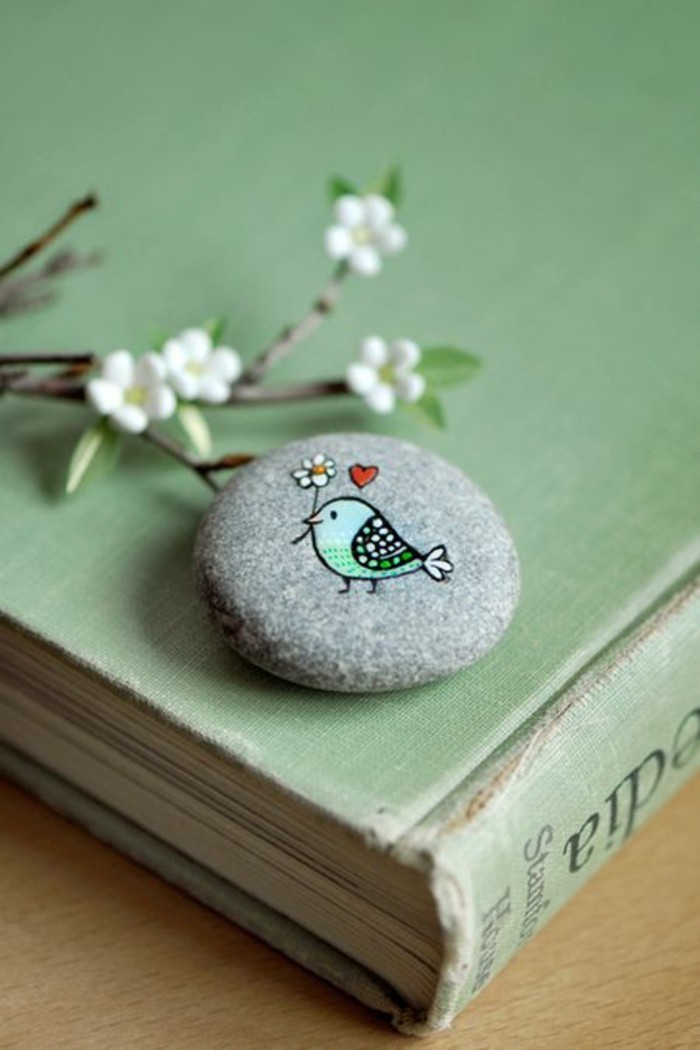 与花和心脏油漆在石头上的鸟