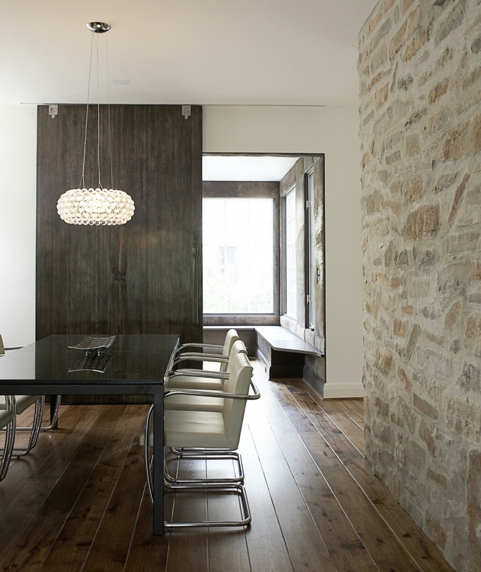 muur ontwerp eetkamer stenen muur houten vloer moderne kroonluchter