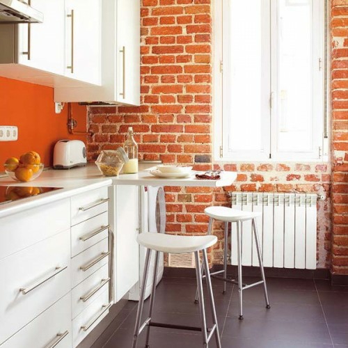cocina blanca pequeña mesa de comedor pared de ladrillo moderna