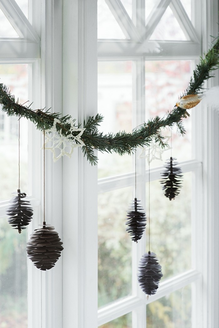Juldekorasjonsvinduet dekorerer ideer med pinecone dekogirlande
