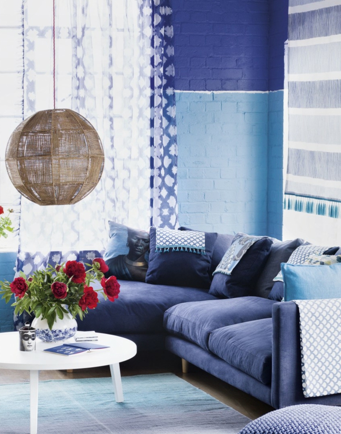 σαλόνι καναπέ μπλε στρογγυλό τραπέζι λουλούδια κρέμονται λάμπα