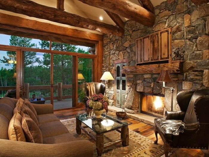 living room stone wall rustic accent wall leather armchair fireplace